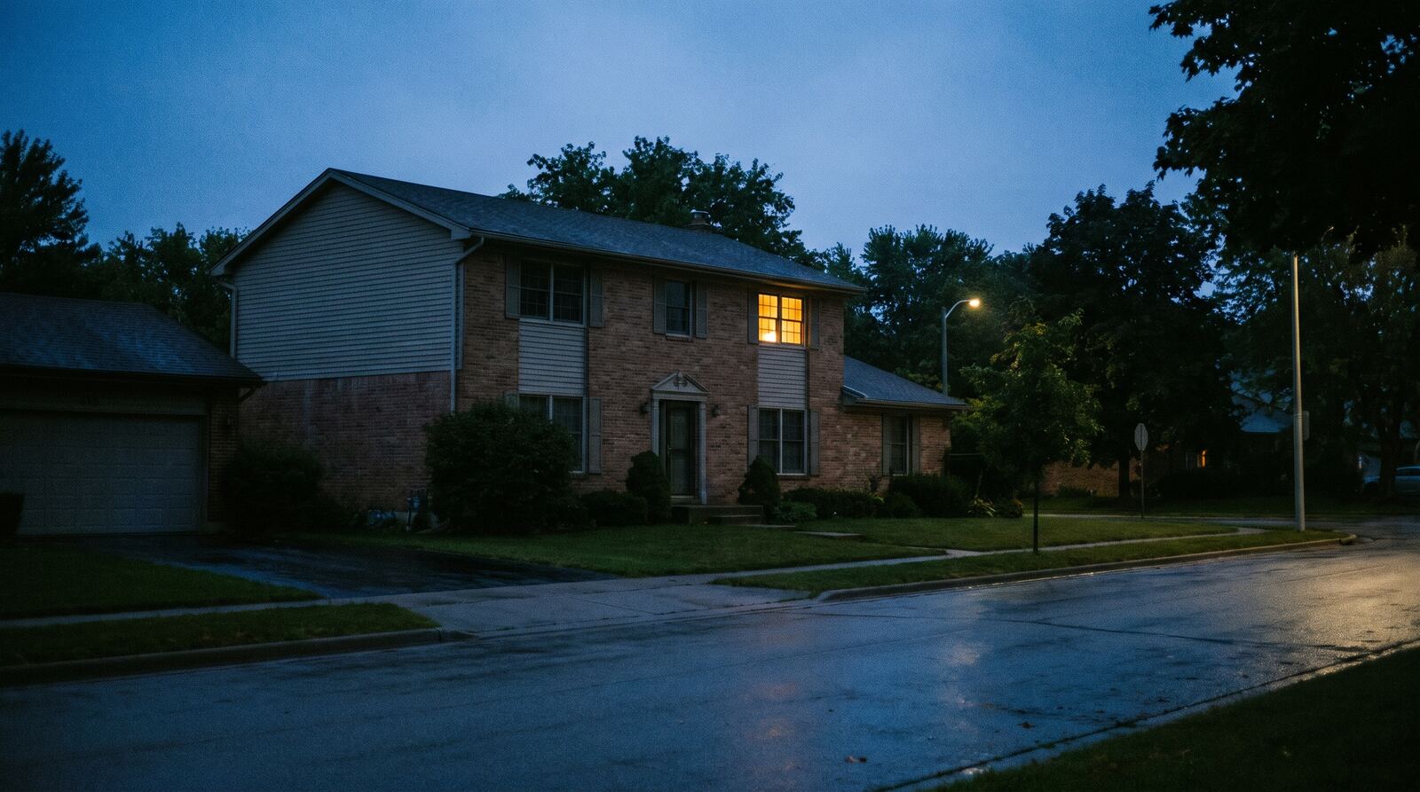 A house at dusk with one lit upstairs window